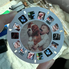 imgi_411_May-include-A-custom-View-Master-reel-featuring-a-Cavalier-King-Charles-Spaniel-dog-cuddling-with-a-baby-wearing-a-fake-mustache-The-reel-also-displ